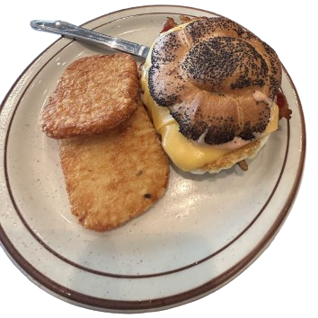 bacon egg and cheese on a croissant with a side hash brown